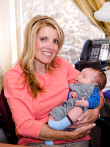 Mardie holding a baby and smiling