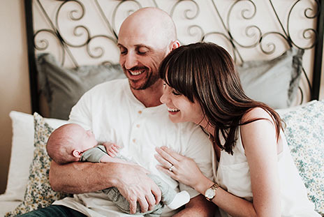New adoptive parents gaze lovingly at their baby