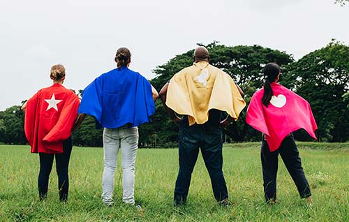 Four friends with superhero capes for a theme party