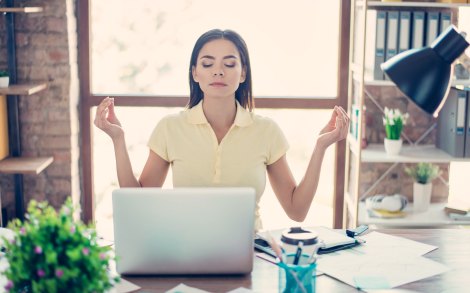 Woman meditates at her desk