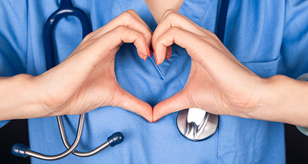 Close up of a nurse making a heart with her hands