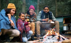 Happy family roasting marshmallows on a camping trip