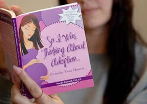 A young woman reading So I Was Thinking About Adoption