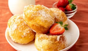Appetizing plate of Portuguese donuts accompanied by fresh strawberries