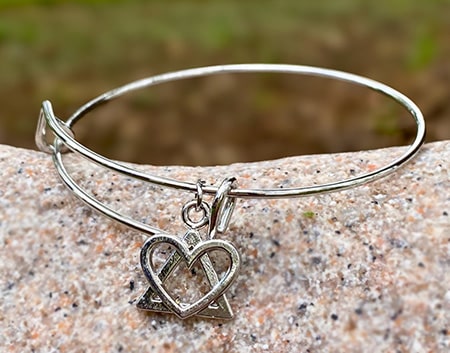 Our bangle bracelet with an adoption symbol charm